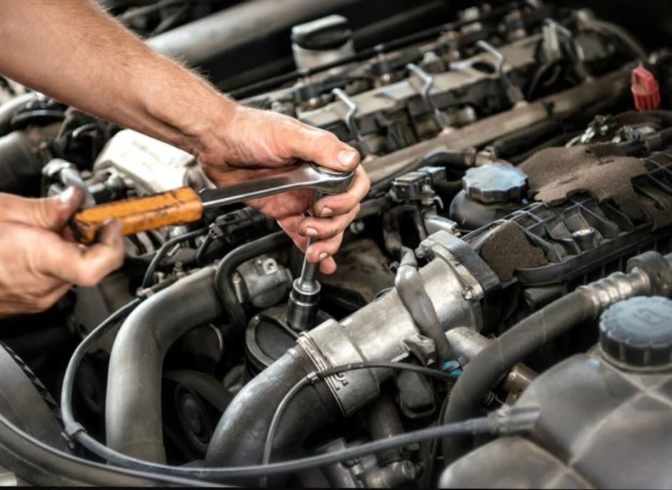 Mechanic repairing a car engine with professional tools at Handy Speedy Mechanical Workshop